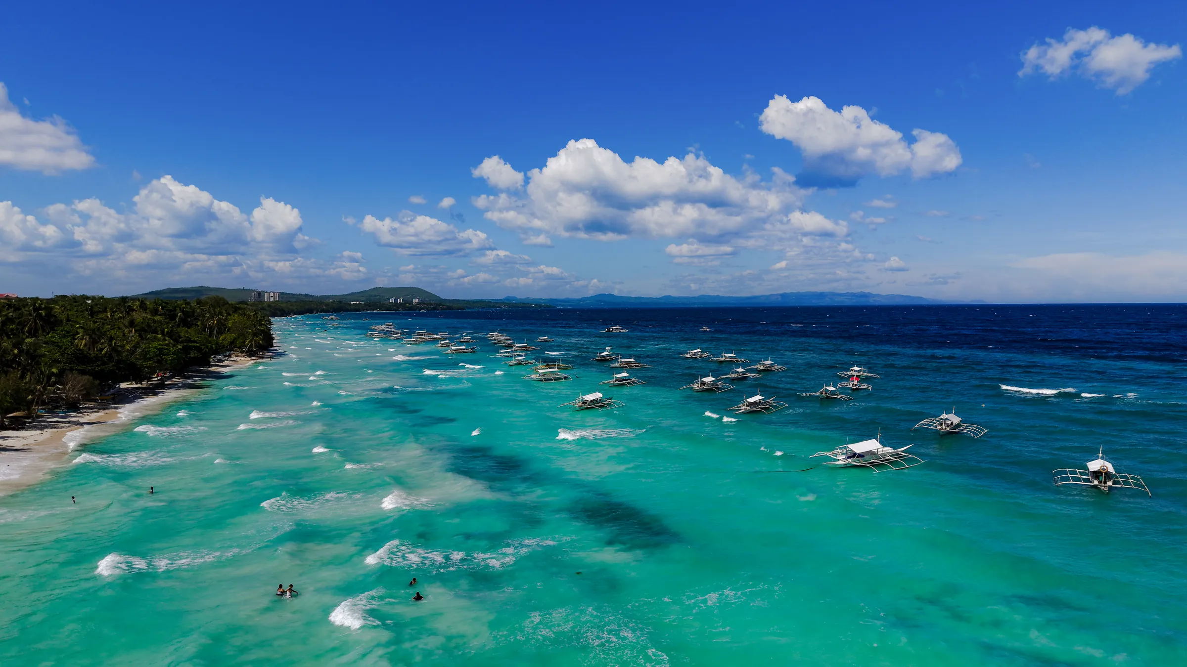 Outrigger bangkas moored in turquoise shallows off Panglao's south coast
